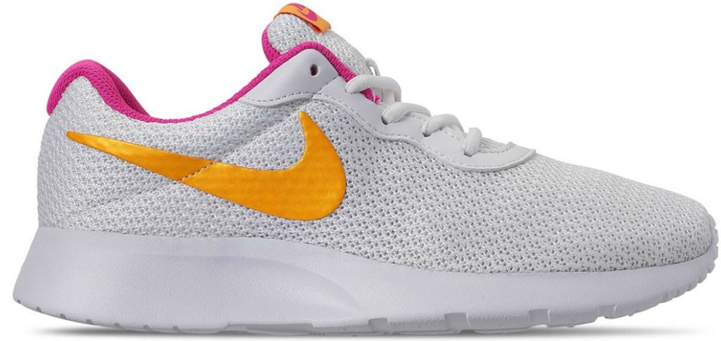 white nike shoes with a yellow/orange swoosh and pink inner