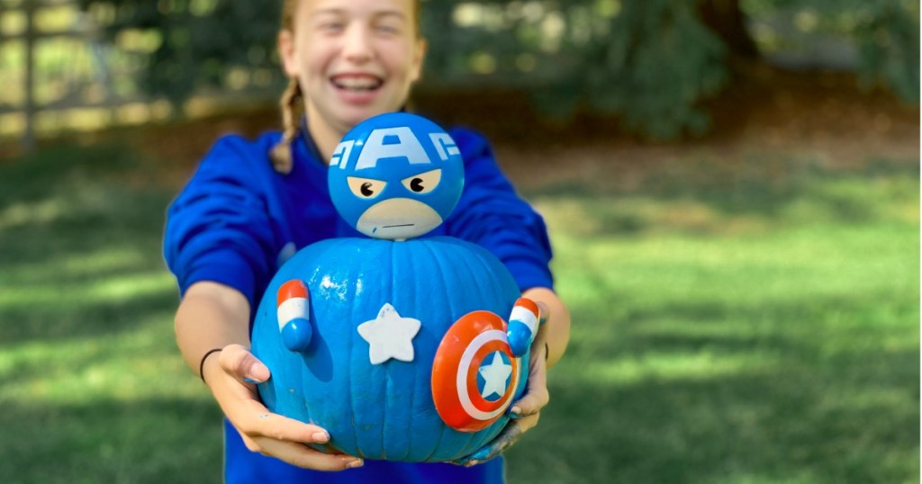 Girl holding No-Carve Pumpkin Kit featuring Captain America