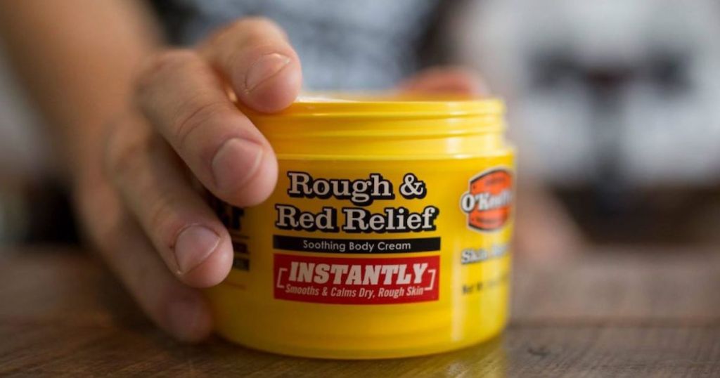 hand holding O'Keeffe's Rough & Red Relief Soothing Body Cream