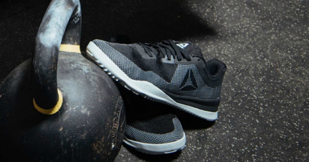 Black and white men's Reebok shoes in gym near kettlebell