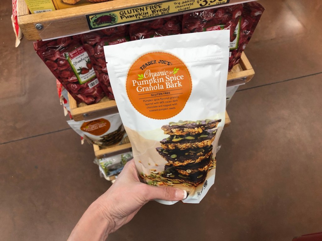 women's hand holding Trader Joe's Organic Pumpkin Spice Granola Bark in store