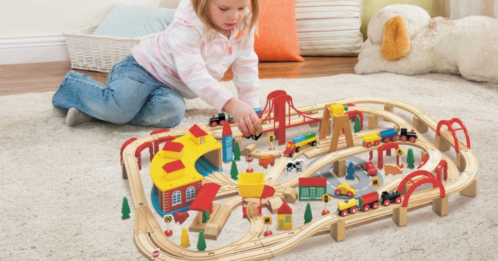 little girl playing with a train set