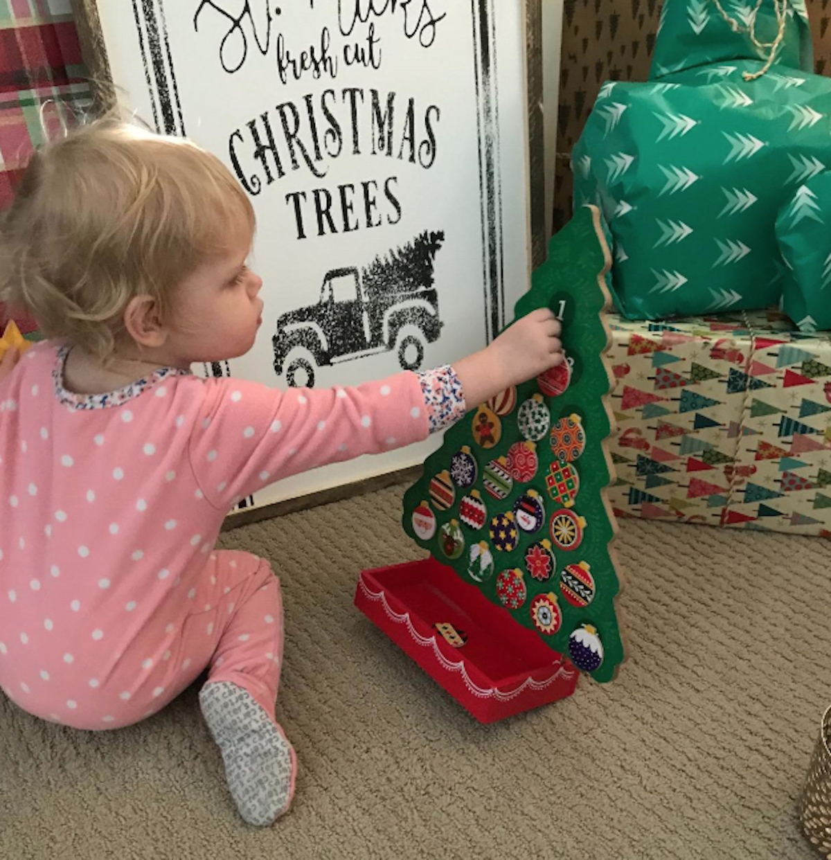 baby girl playing with advent tree countdown calendar