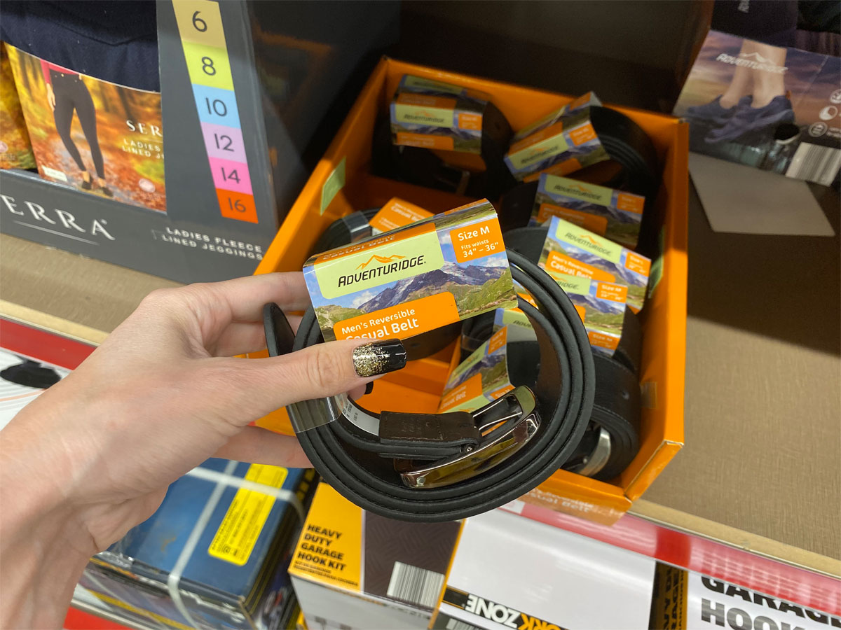 adventurist men's casual belt being held up in front of shelf at Aldi