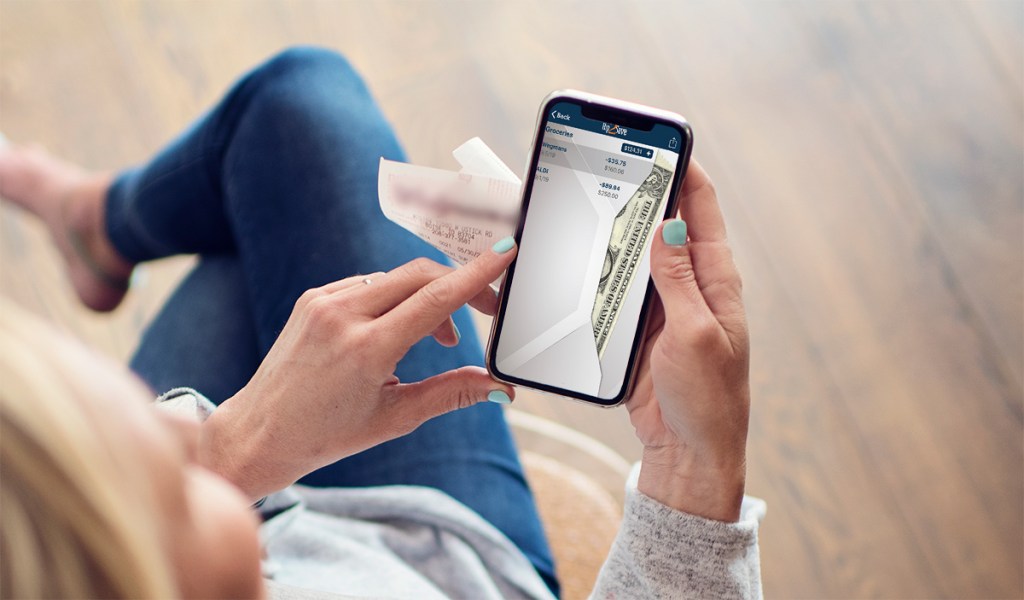 woman on smartphone using envelope budget