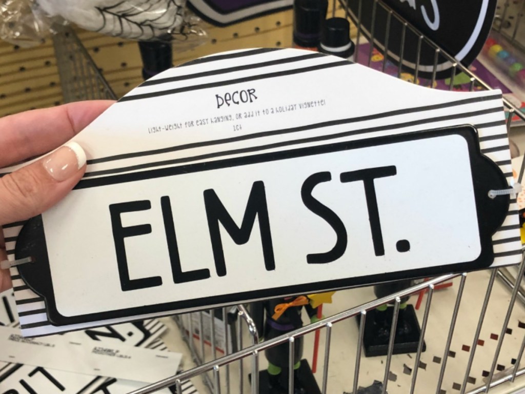 hand holding small metal sign by store display