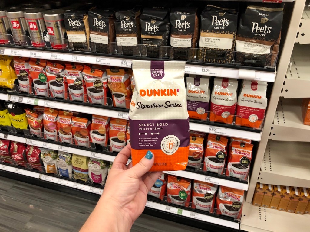 dunkin donuts signature series coffee bag held up in front of store shelf