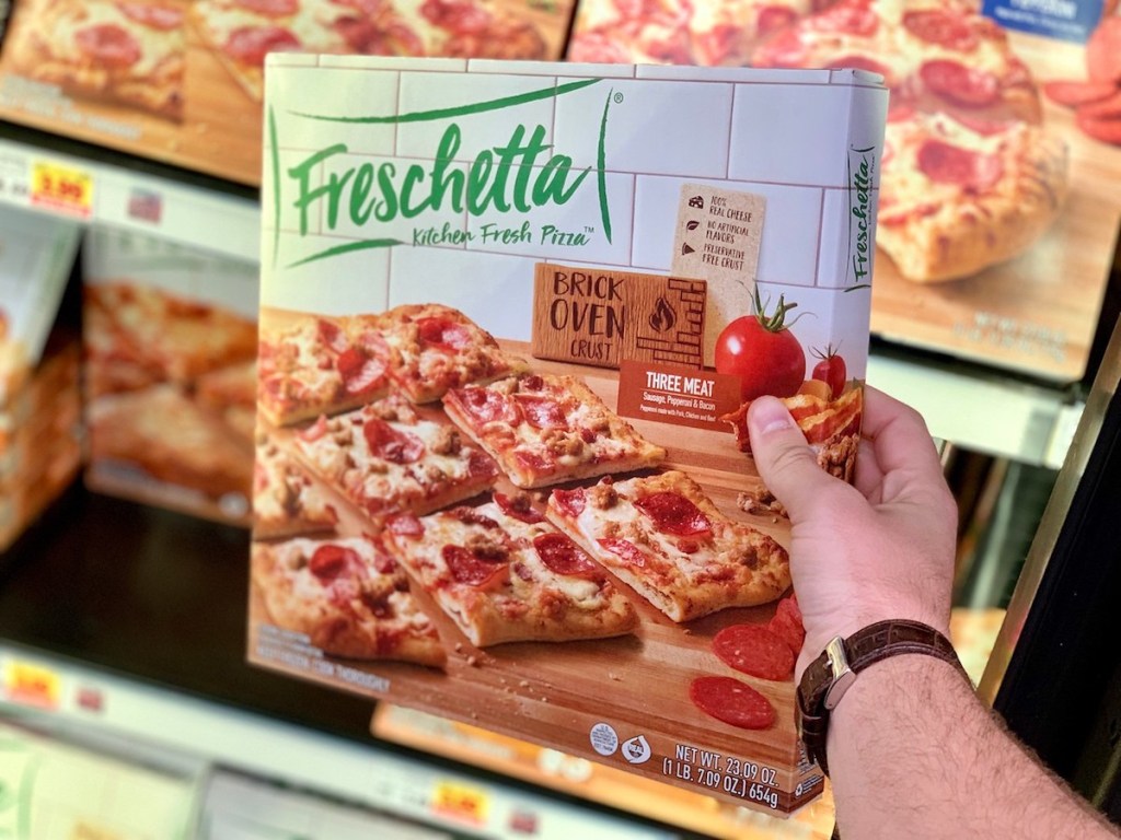 Hand holding freschetta pizza