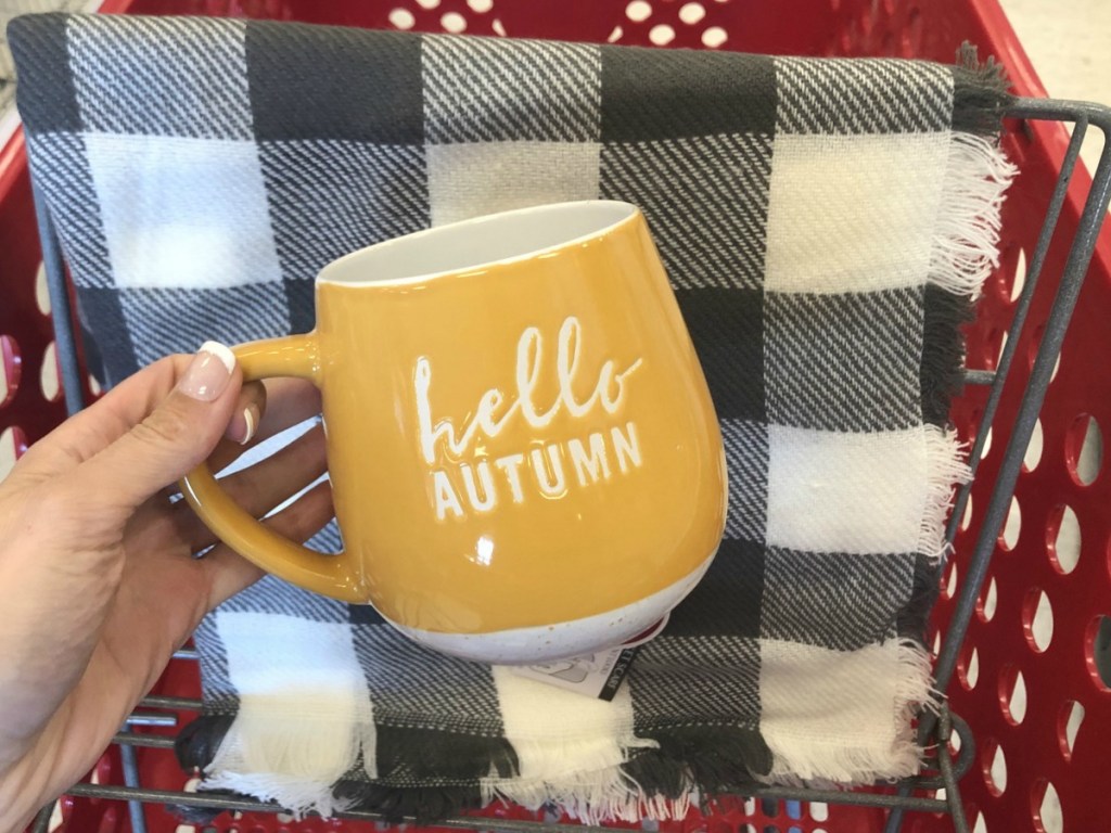 hand holding orange mug by scarf