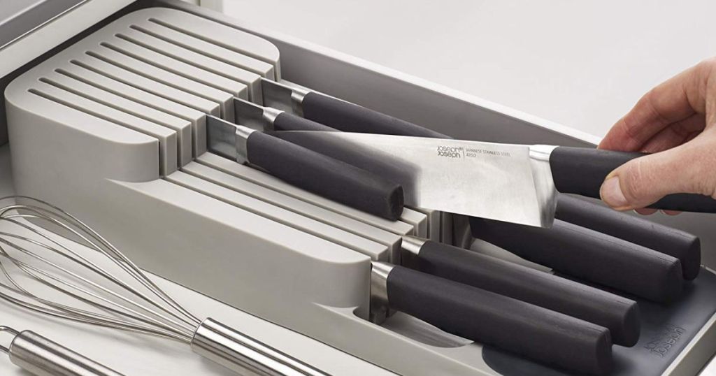 hand putting knife in knife organizer in drawer