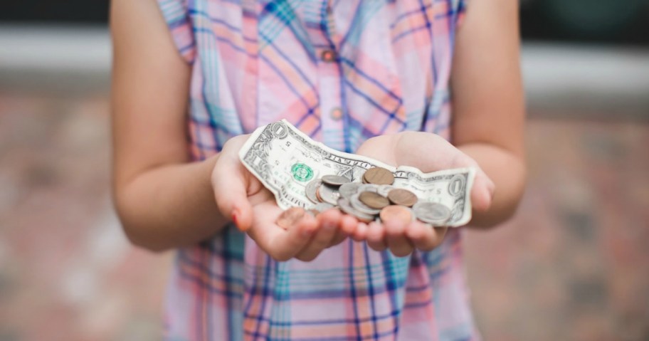 Little girl holding out cash