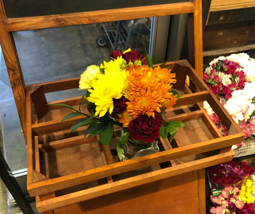 mason jar of flowers on wooden cart
