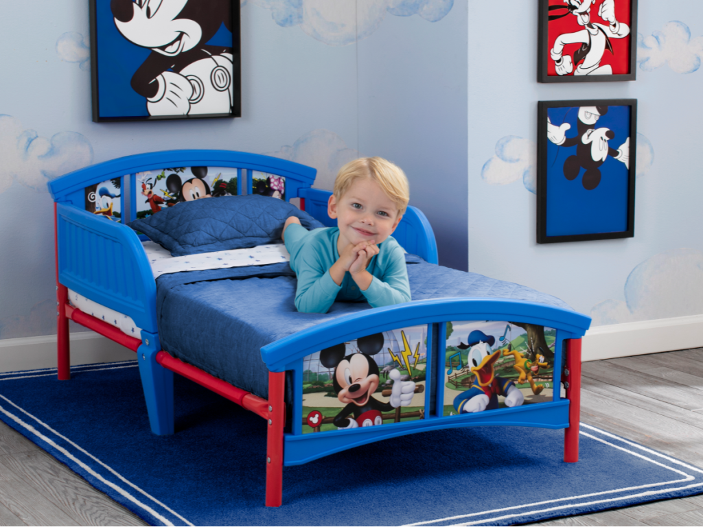mickey mouse toddler bed w/ little boy laying on it