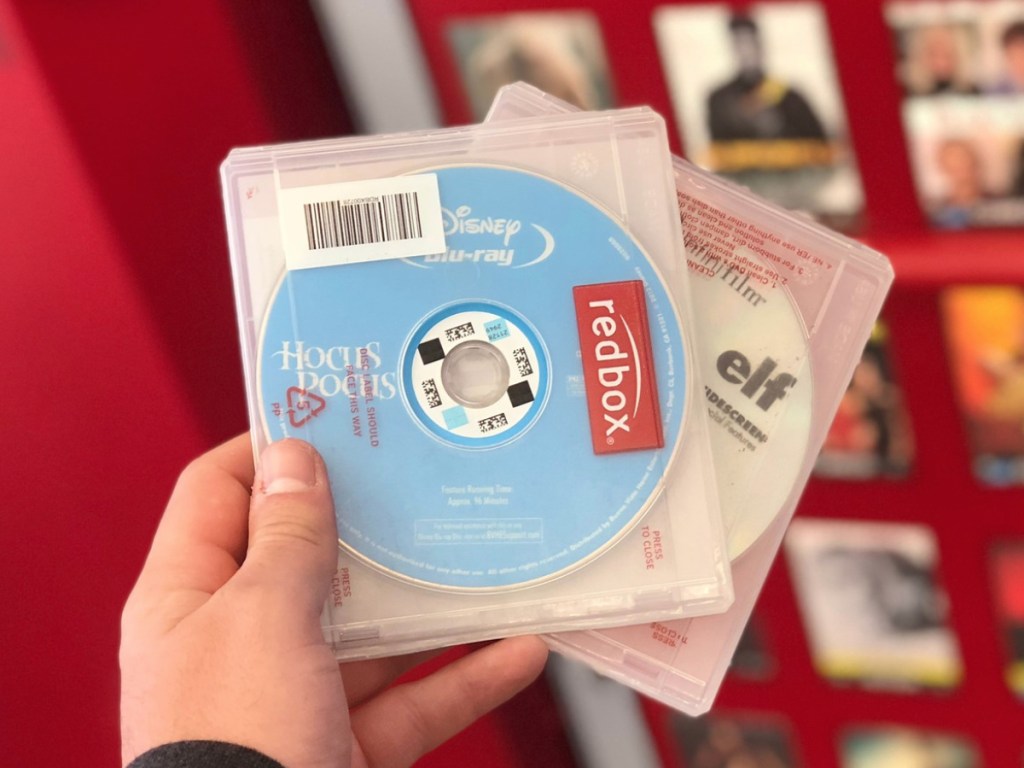 man hand holding two redbox rentals