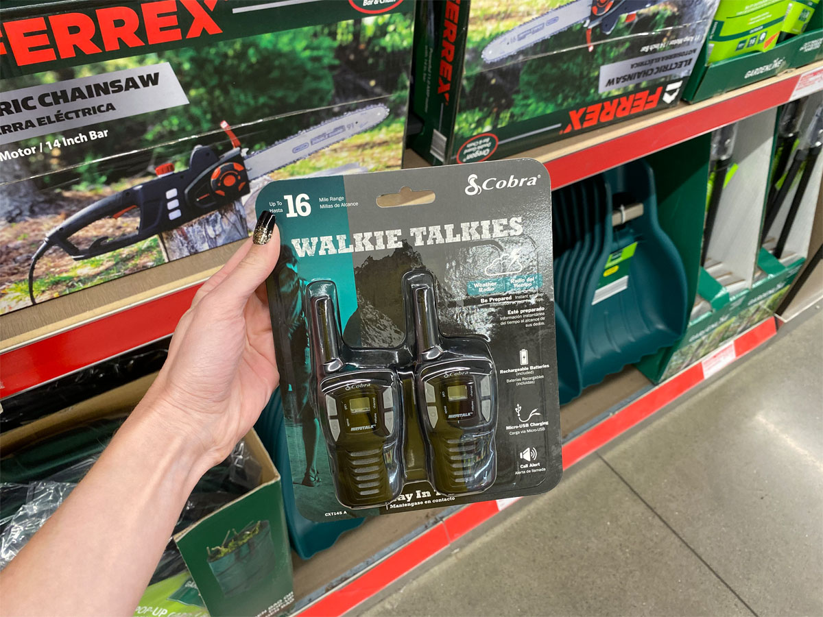 cobra 2 pack of walkie talkies being held up in front of shelf at aldi