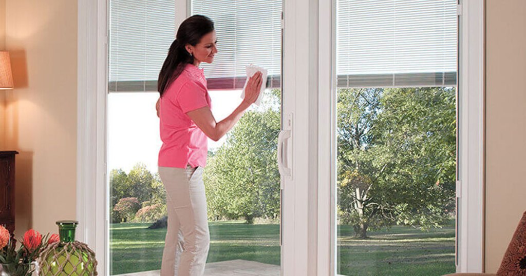 woman cleaning window with cloth