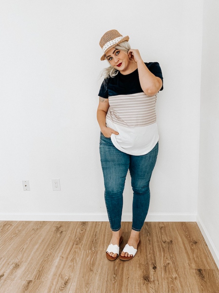 woman wearing fedora hat, striped tee and jeans 