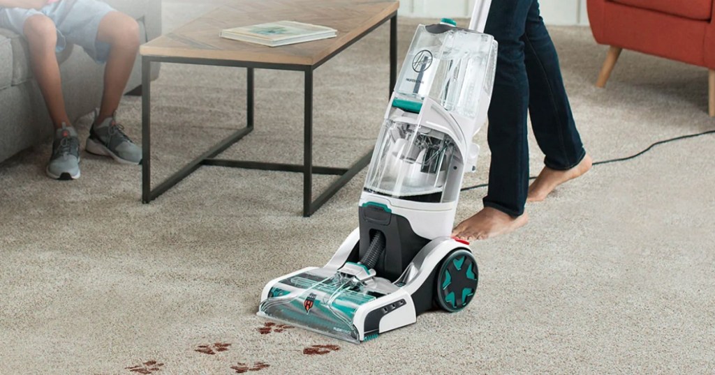 man cleaning carpet with carpet cleaner
