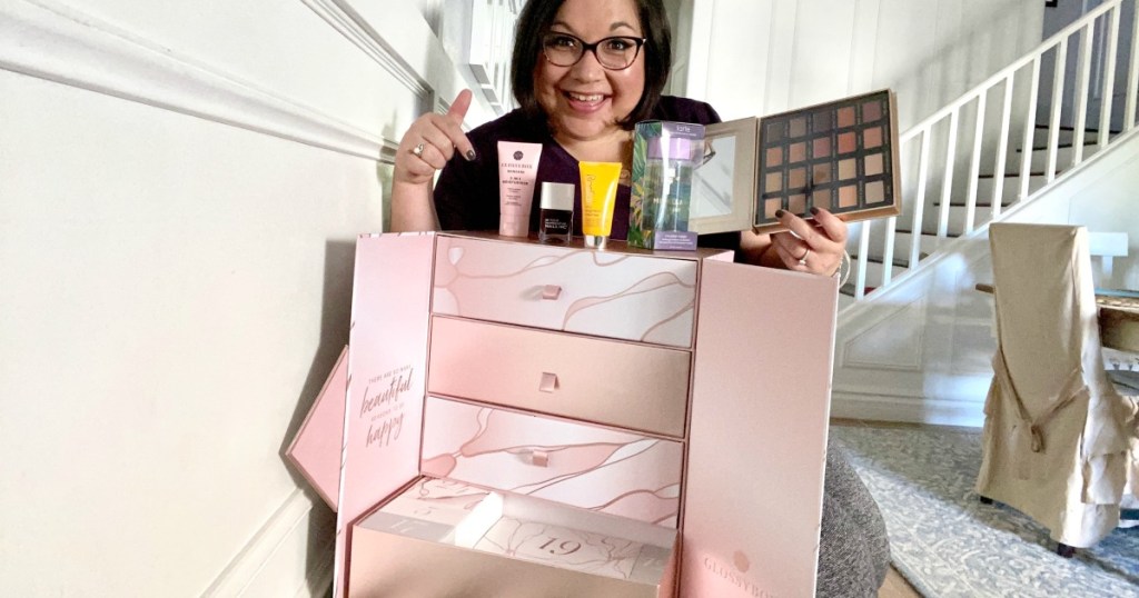 woman holding items from glossy box advent calendar 