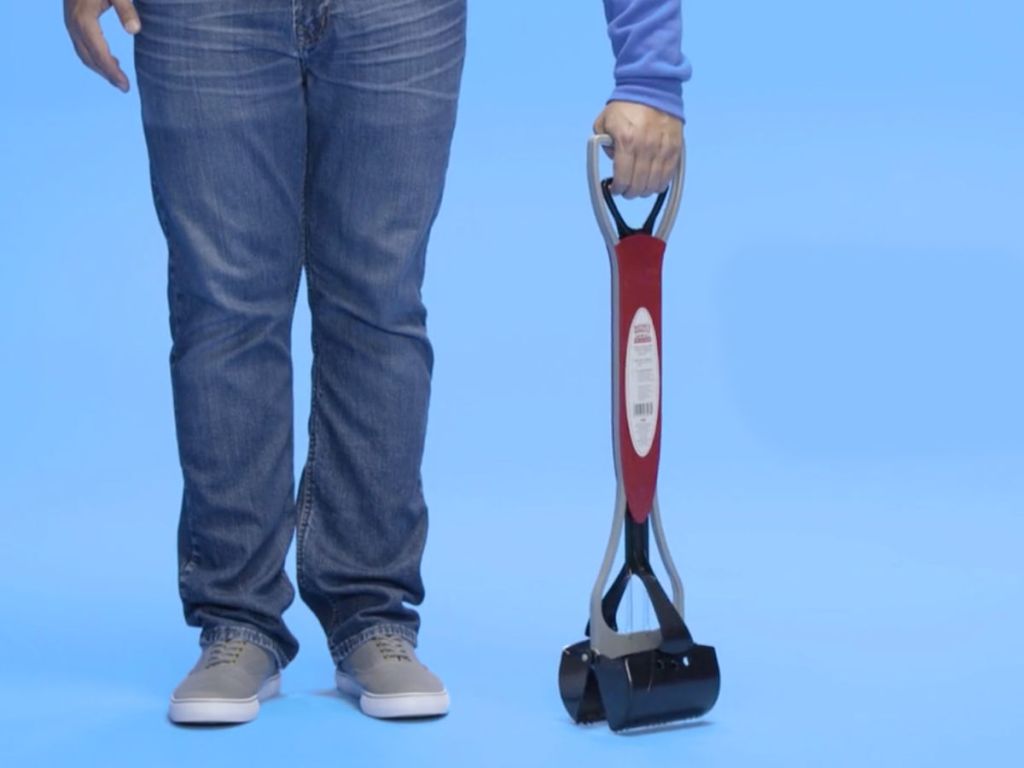 man holding Nature's Miracle Non-Stick Advanced Pet Waste Jaw Scoop