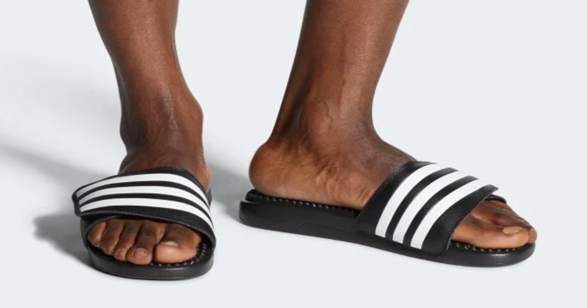 Men's feet wearing Adidas Slides