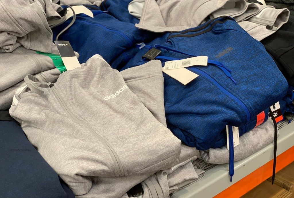 piles of gray and blue adidas track jackets hoodies