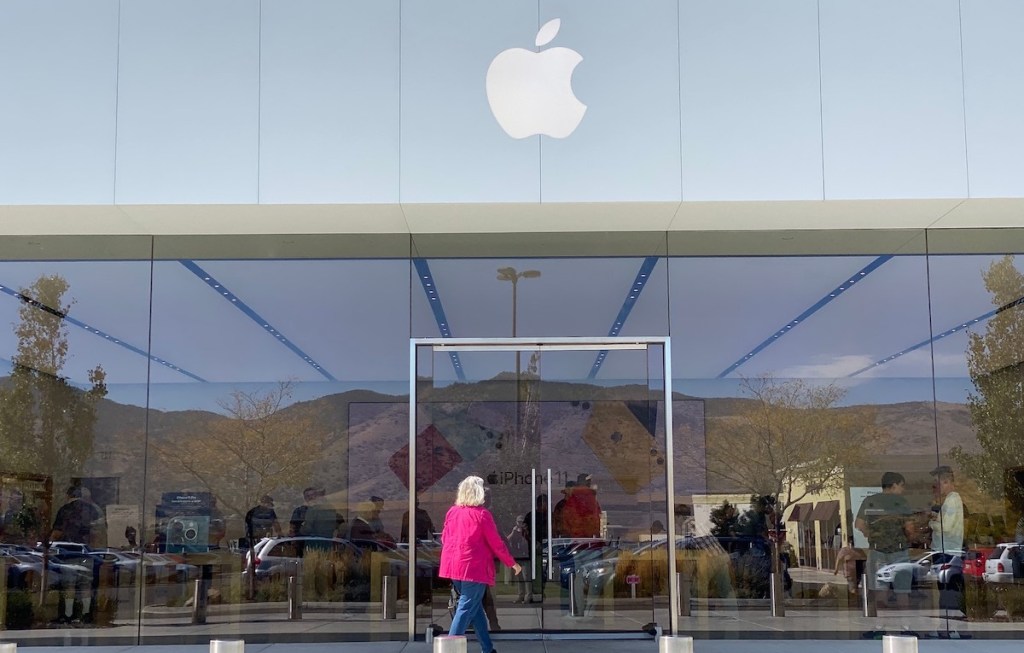 woman walking into apple store front outside