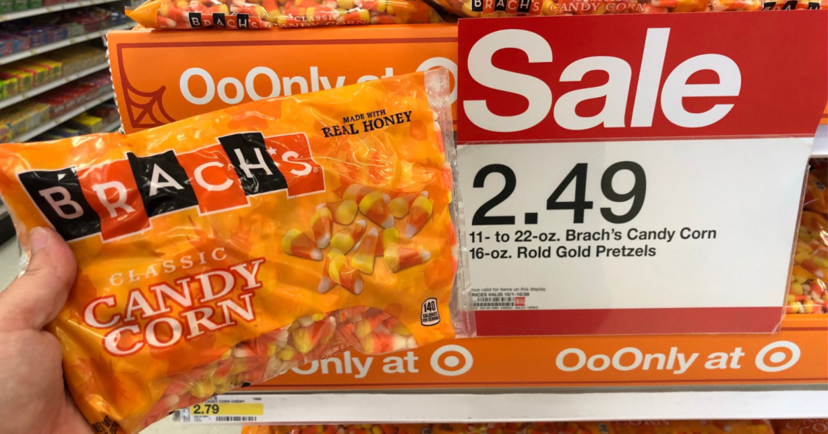hand holding brachs candy corn with sale sing