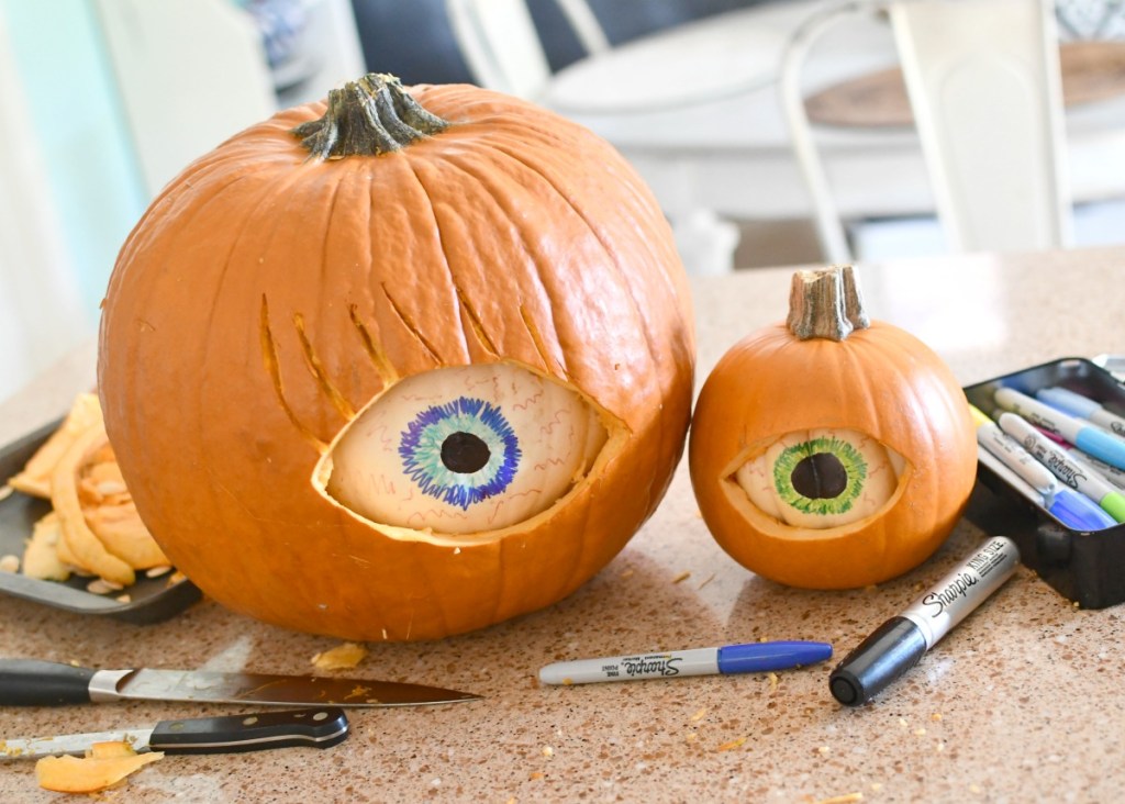 carving eyeball pumpkin using two pumpkins