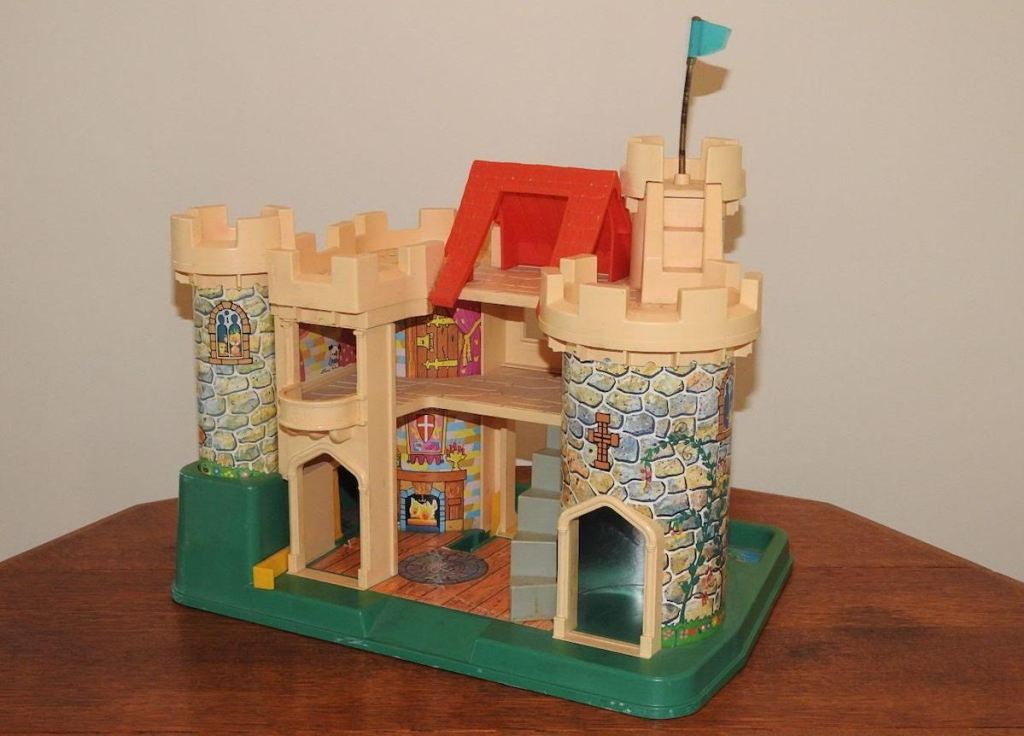 vintage fisher price castle sitting on wood table