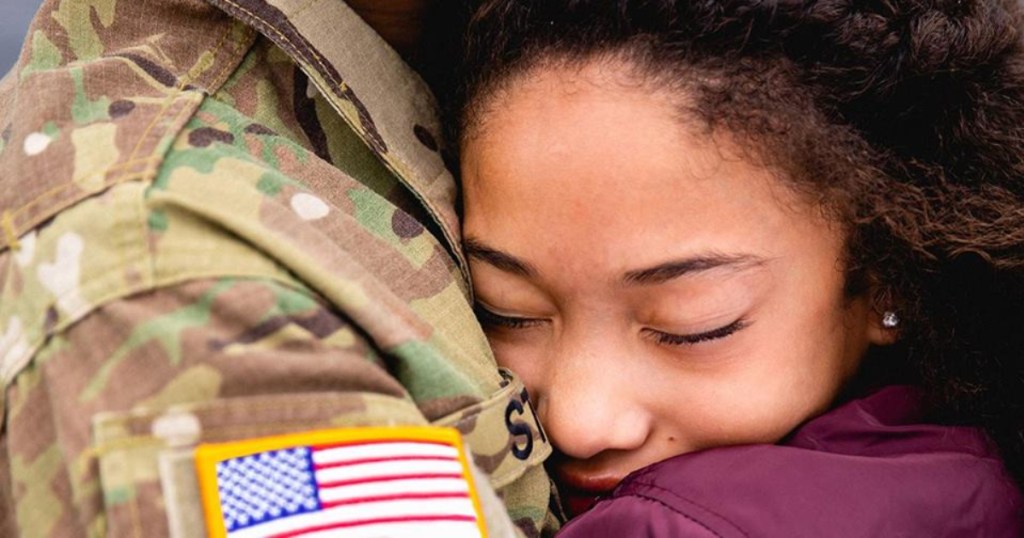 Girl hugging military personnel
