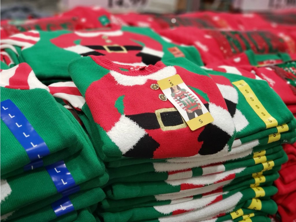 pile of Christmas sweaters on display in store