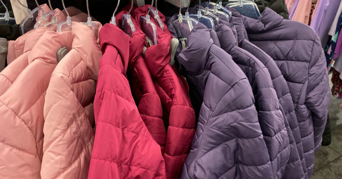 girls pastel colored puffer coats on store rack