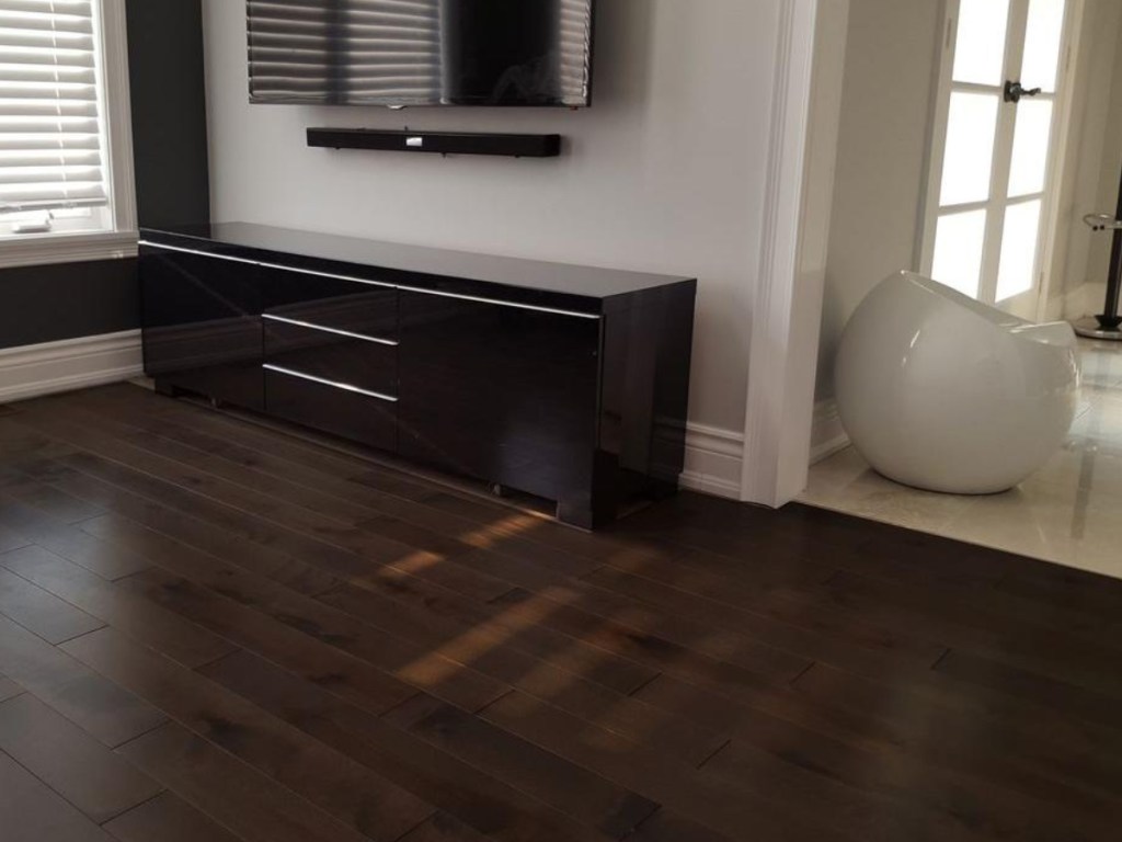 dark wood laminate flooring with dresser and tv in background