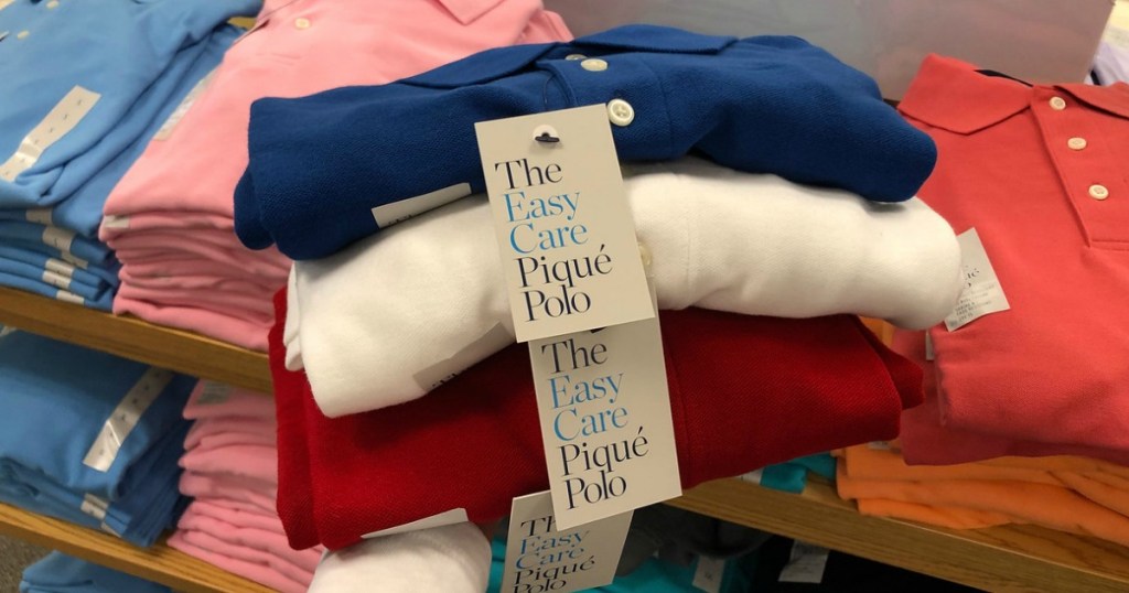 hand holding up folding polos in different colors