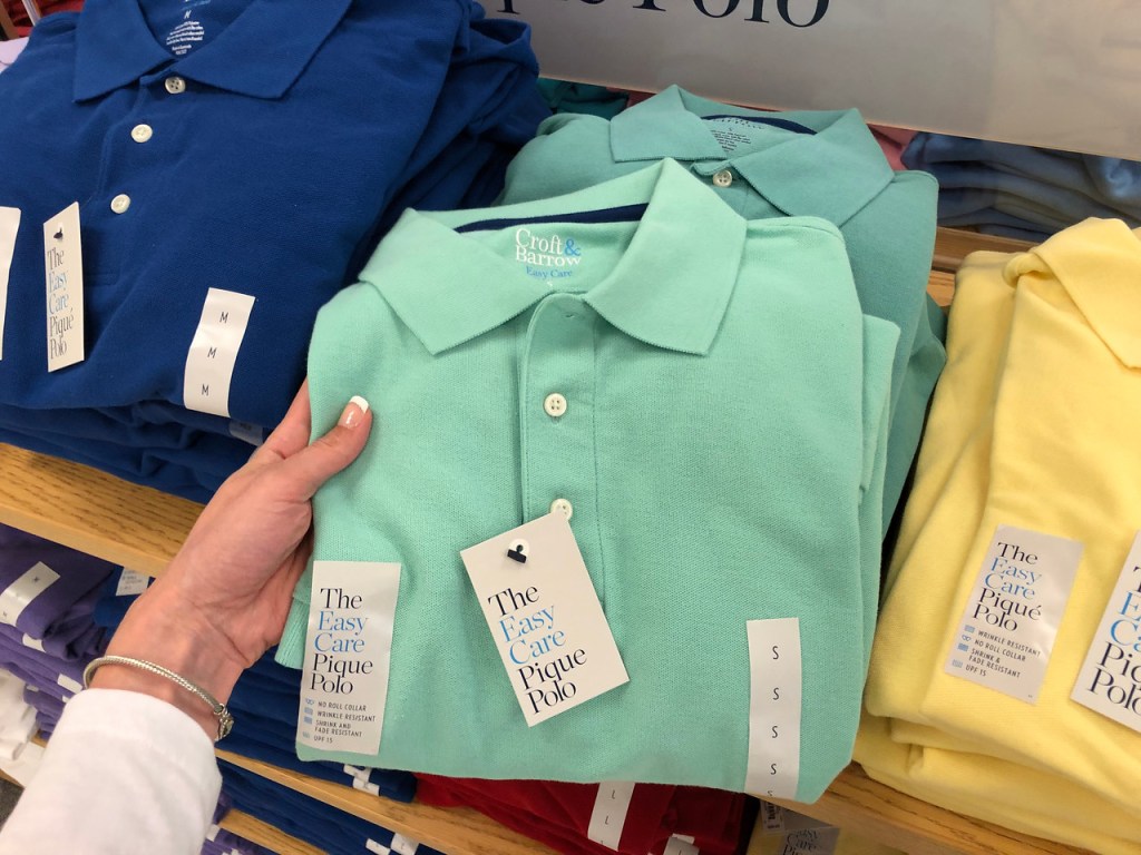 hand holding mint colored mans polo in store