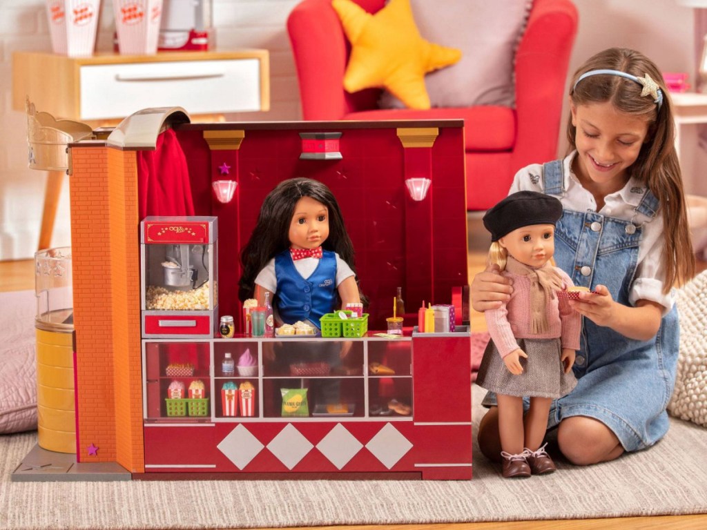 girl playing with movie set and dolls