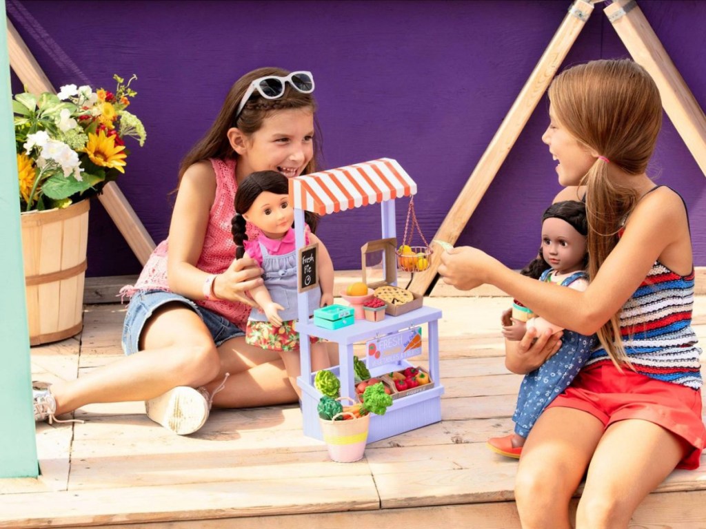 girls playing with farmers market set and dolls