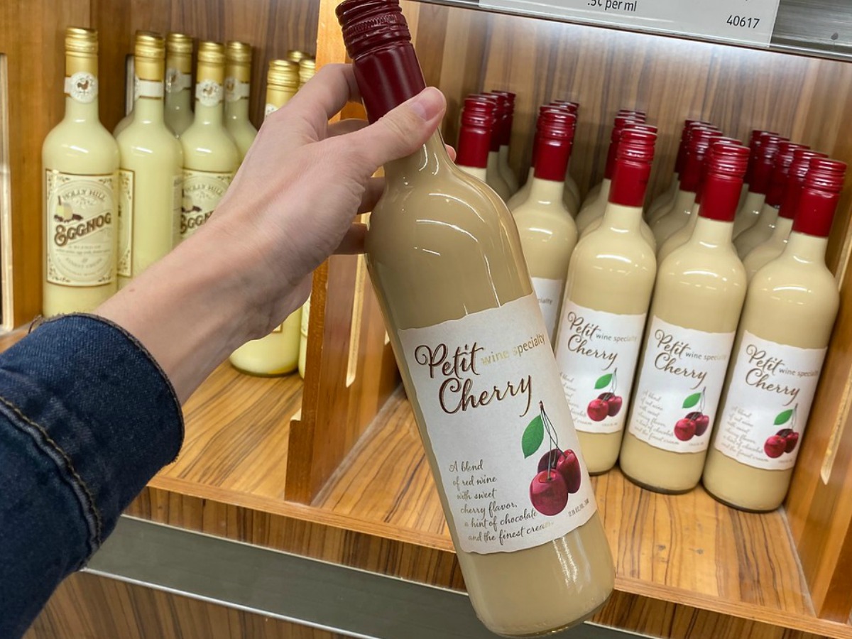 hand holding bottle of wine by store display