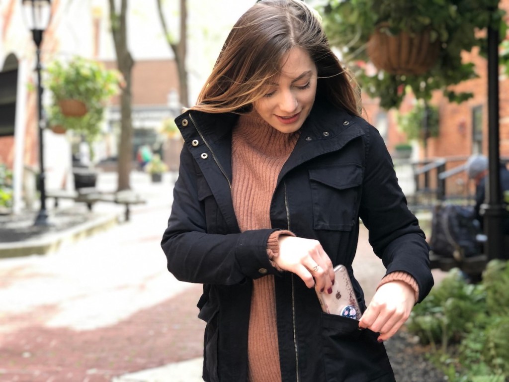 woman putting phone in cargo jacket pocket