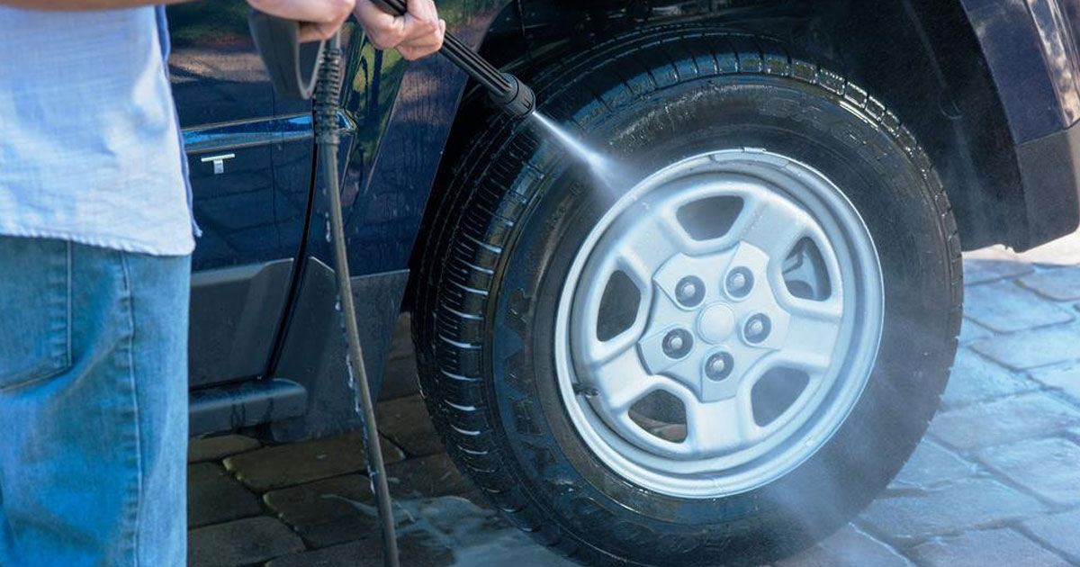 guy pressure washing tire of car with armor all pressure washer at home depot