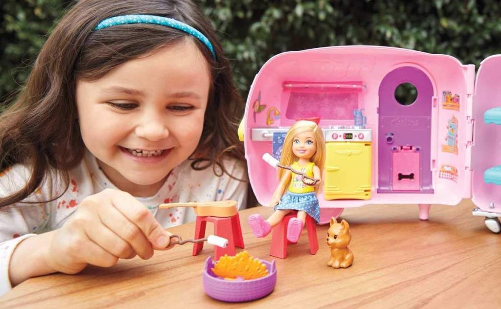 girl playing with Barbie Chelsea Camper