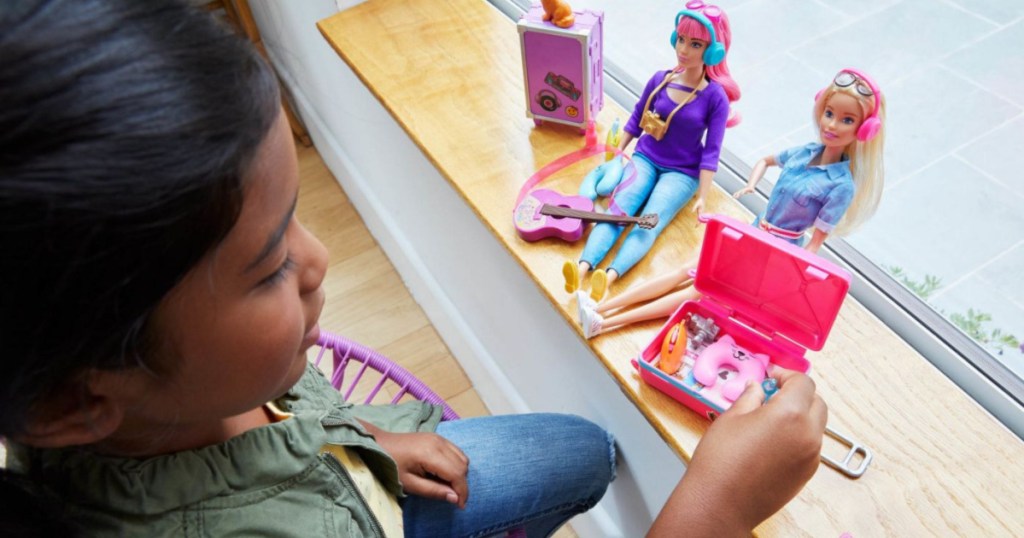 girl playing with barbie set