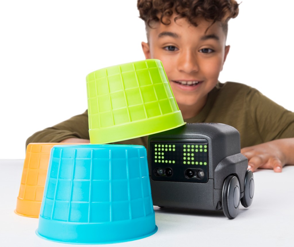 boy playing with Boxer Robot toy and stacking cups