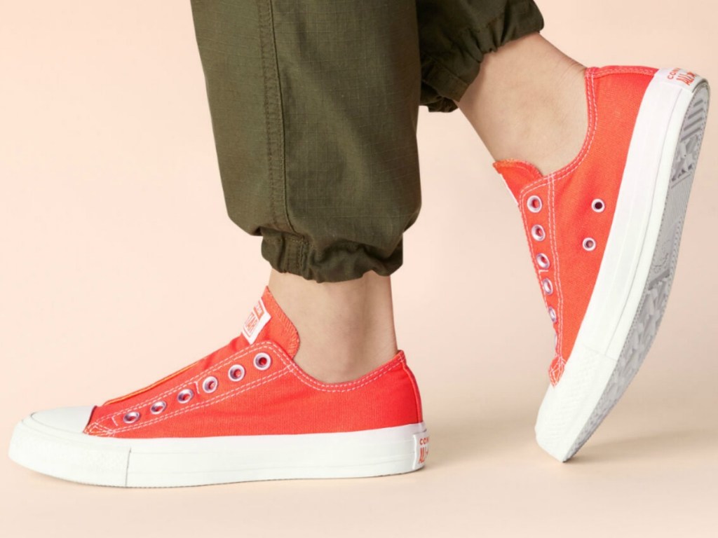 Woman wearing coral colored slip on shoes