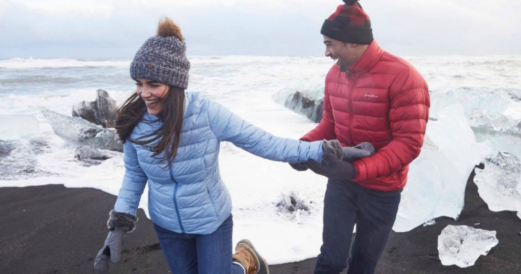 Man & woman at beach wearing Eddie Bauer CirrusLite Down Jacket