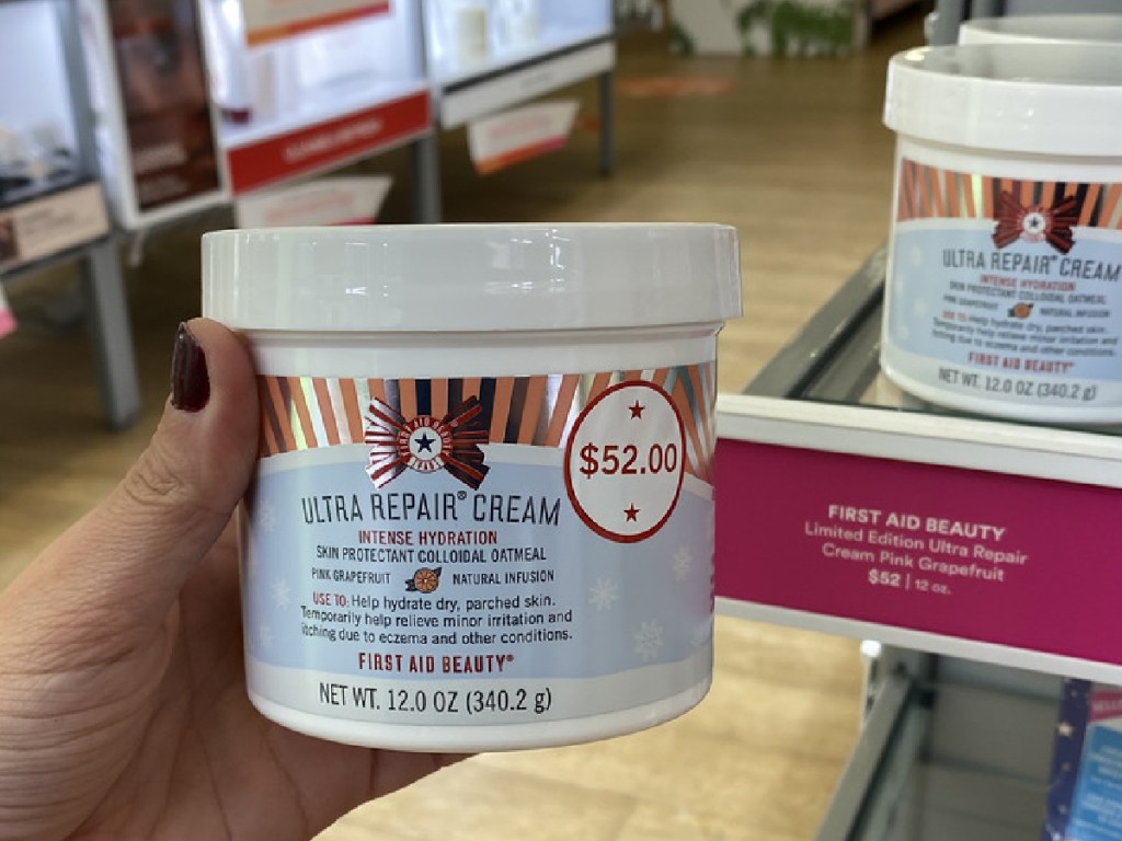 hand holding large tub of body cream in store