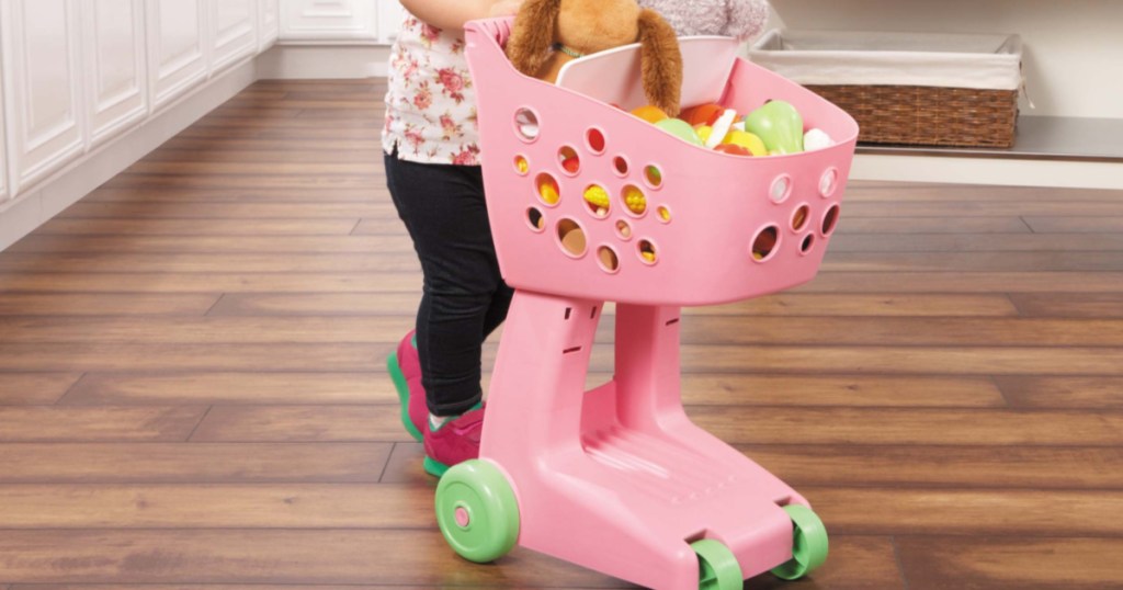 kid playing with pink little tikes lil shopper