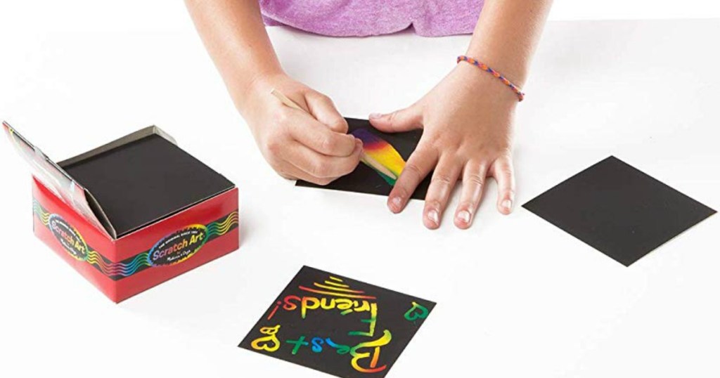 girl using Melissa & Doug Scratch Art notes