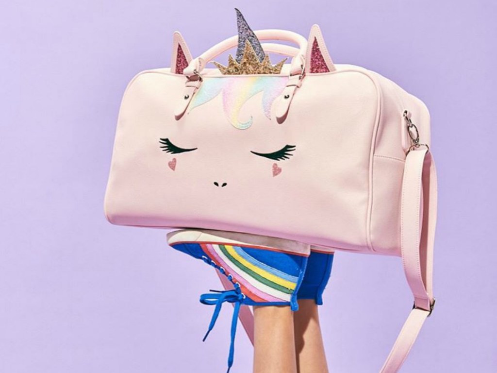 feet holding up an OMG! Unicorn duffel bag